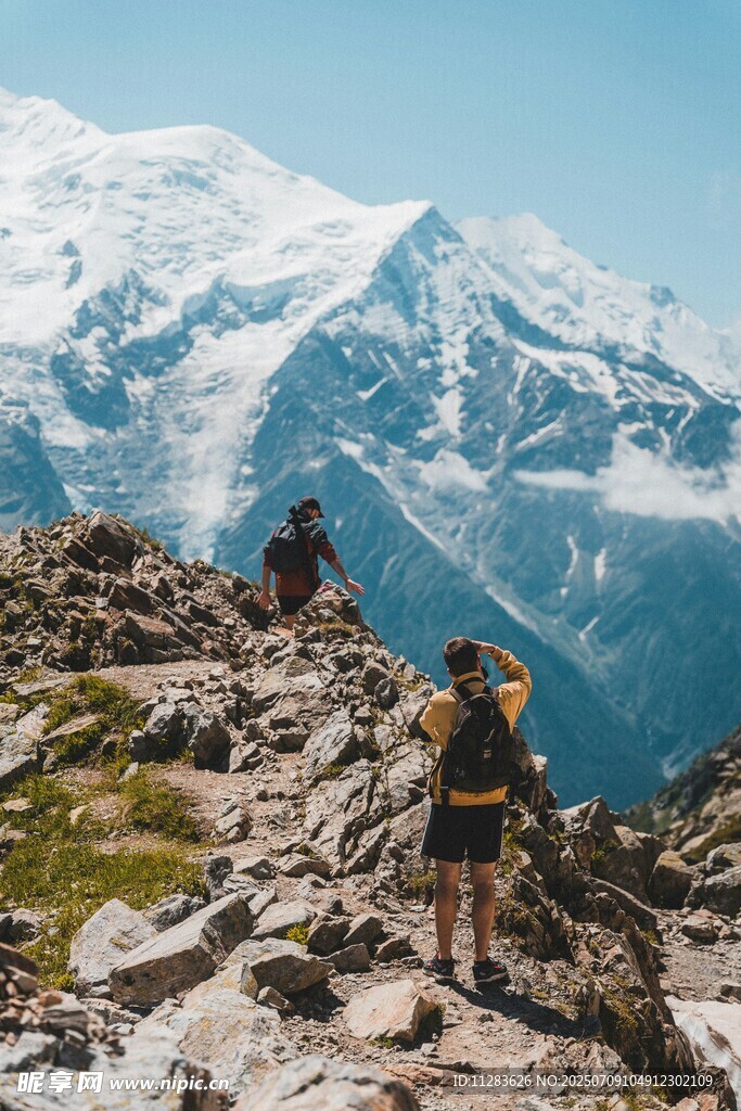 徒步者攀登雪山岩石间
