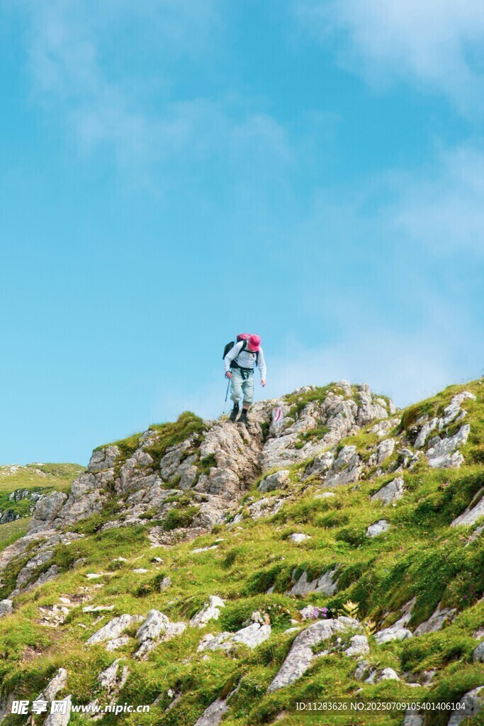 徒步者攀登绿意盎然的山坡