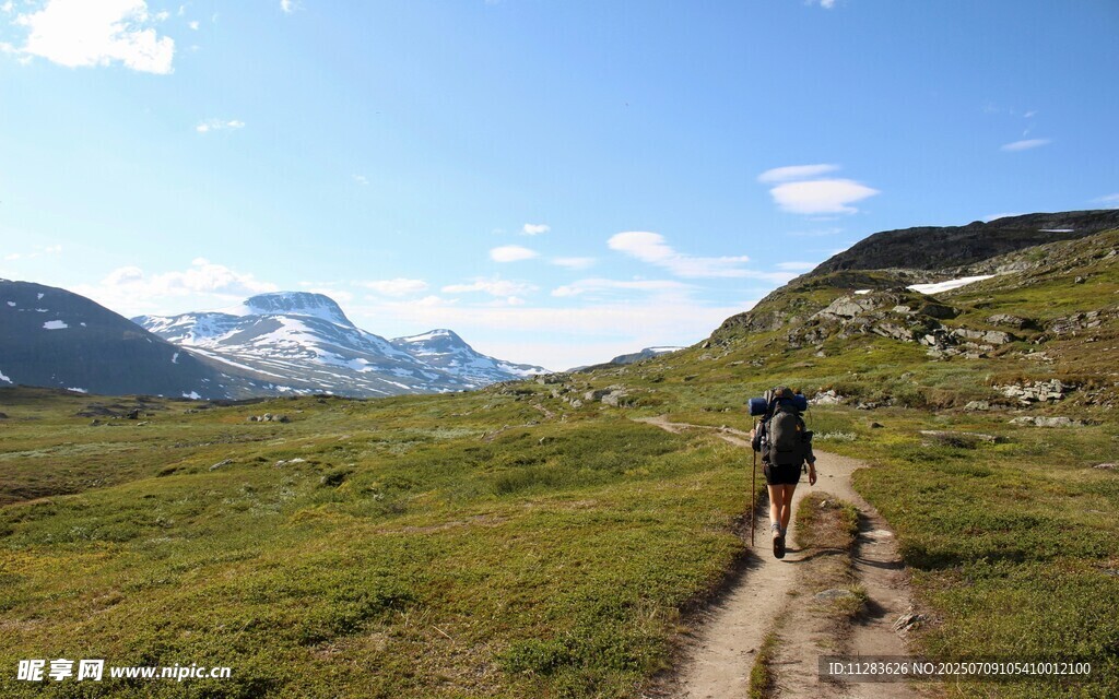 徒步者穿行于山间草地