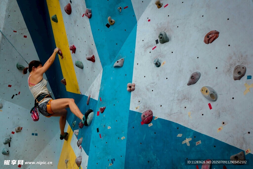 攀岩者奋力攀爬多彩岩壁