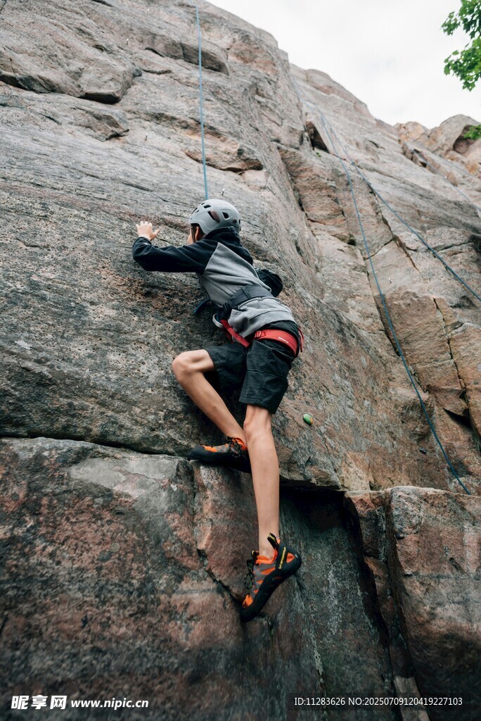 攀岩者专注攀爬陡峭岩壁