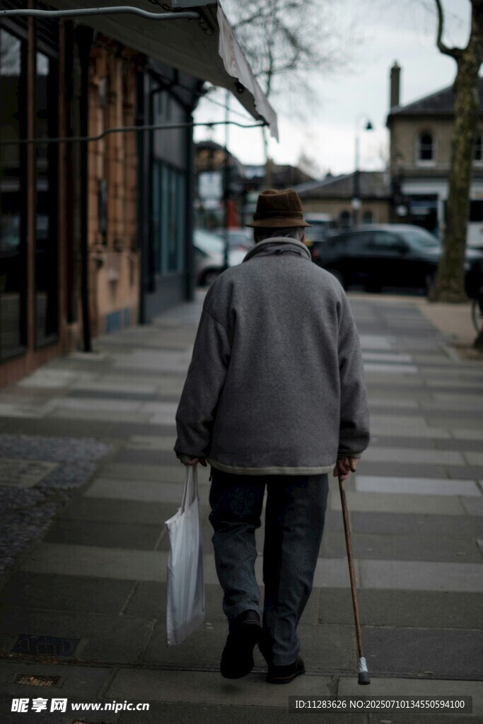 老人拄拐独行街道