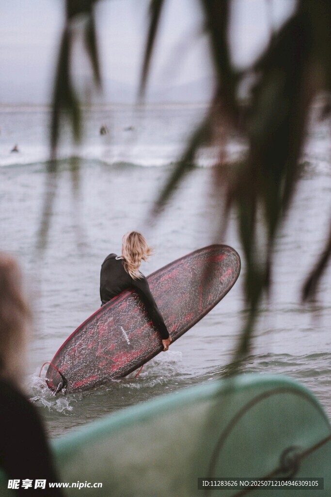 海边冲浪者准备踏浪前行