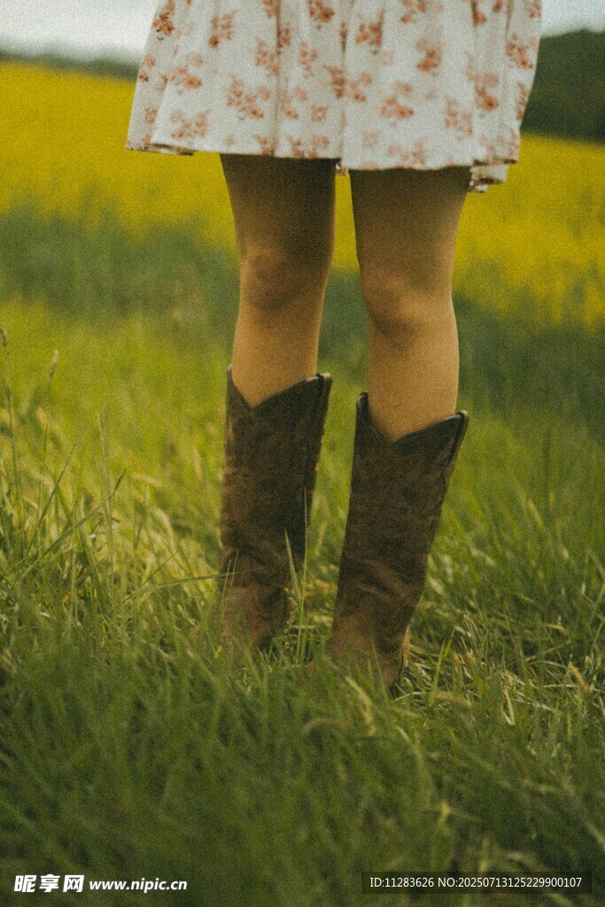 女孩草地中穿着碎花裙与靴子