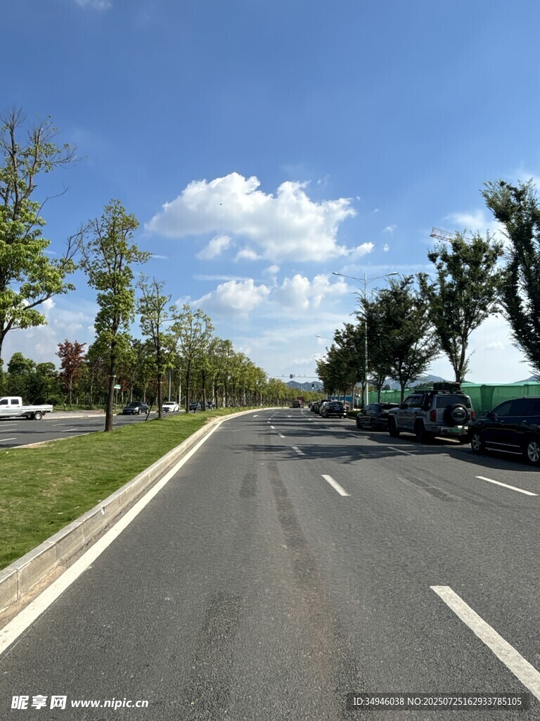 宽阔公路旁绿树蓝天白云