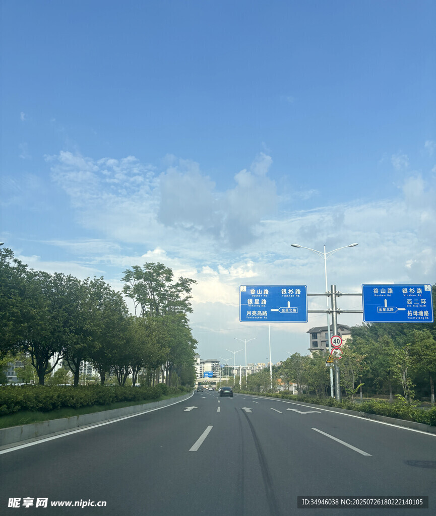 宽阔公路与路旁绿树蓝天