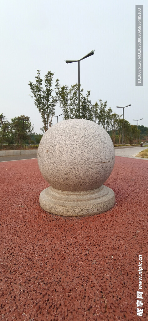 户外红色地面上的石球