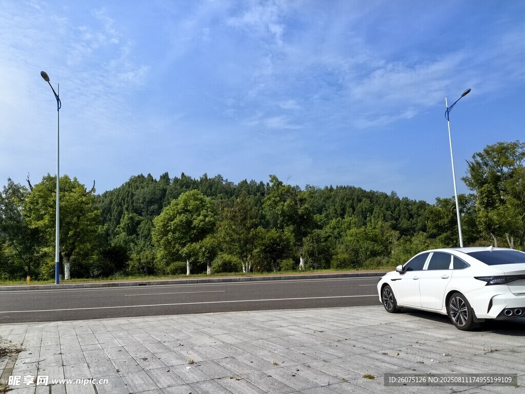 宽广场地与公路旁的白色轿车