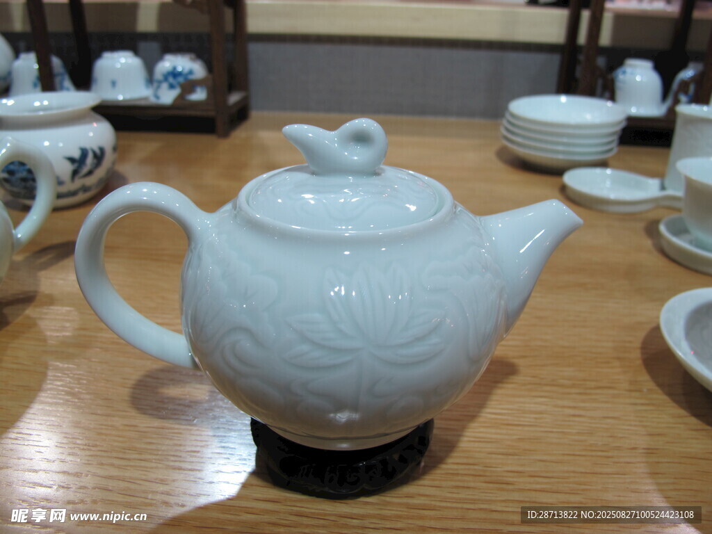 白色陶瓷茶壶置于桌上