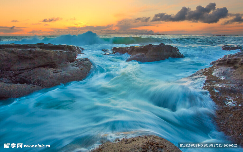 夕阳下海浪拍打礁石美景