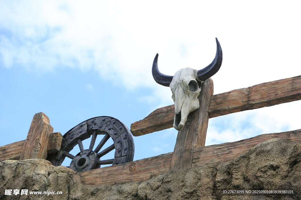 木栅栏上的牛头骨与车轮