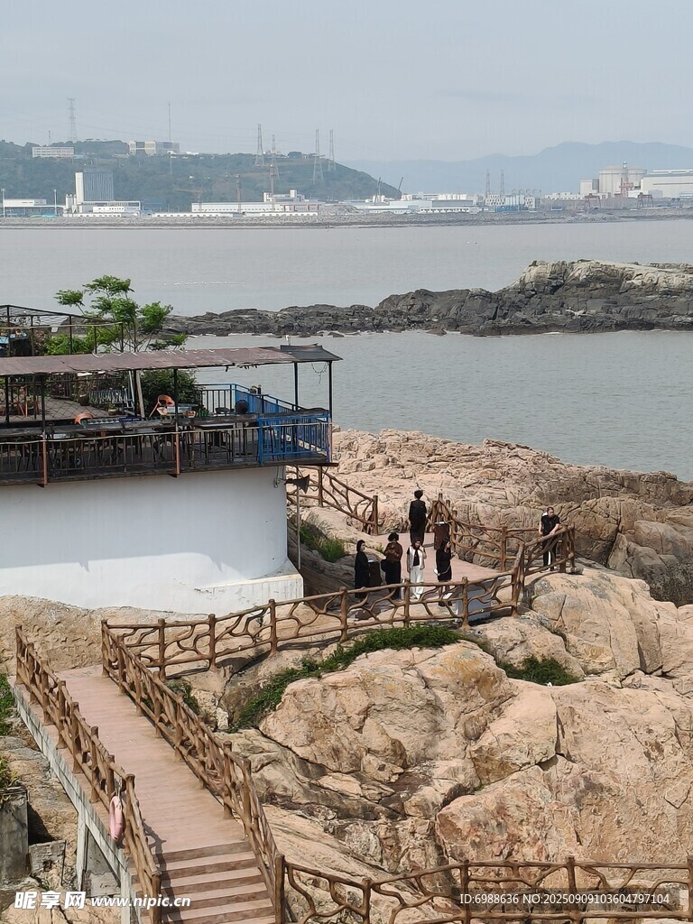 海边栈道旁的岩石与游人