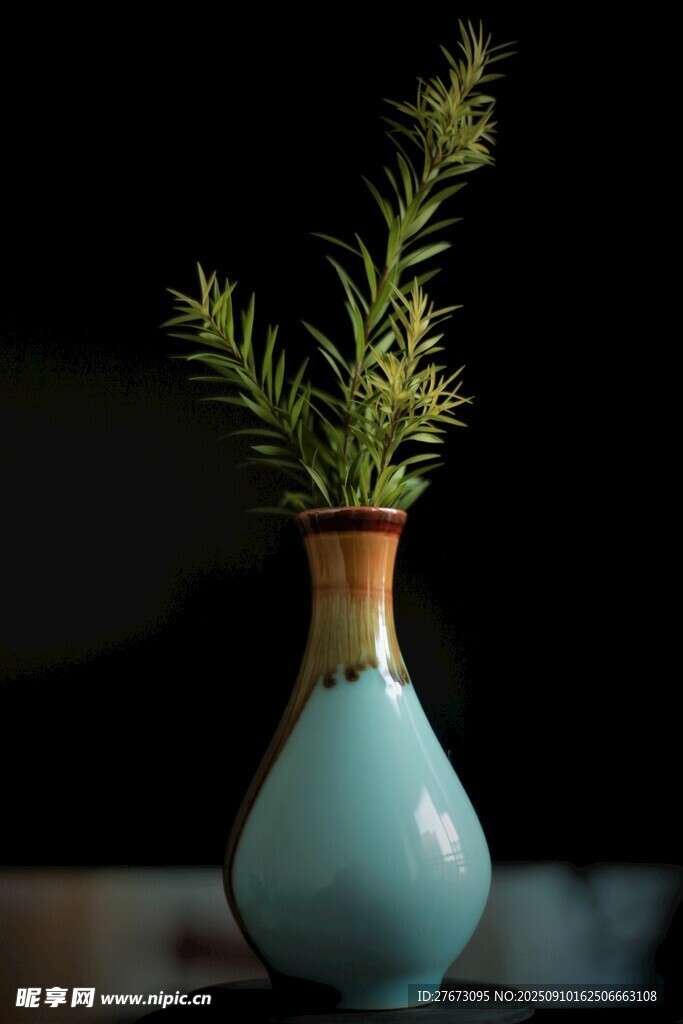 蓝瓶中插着翠绿植物