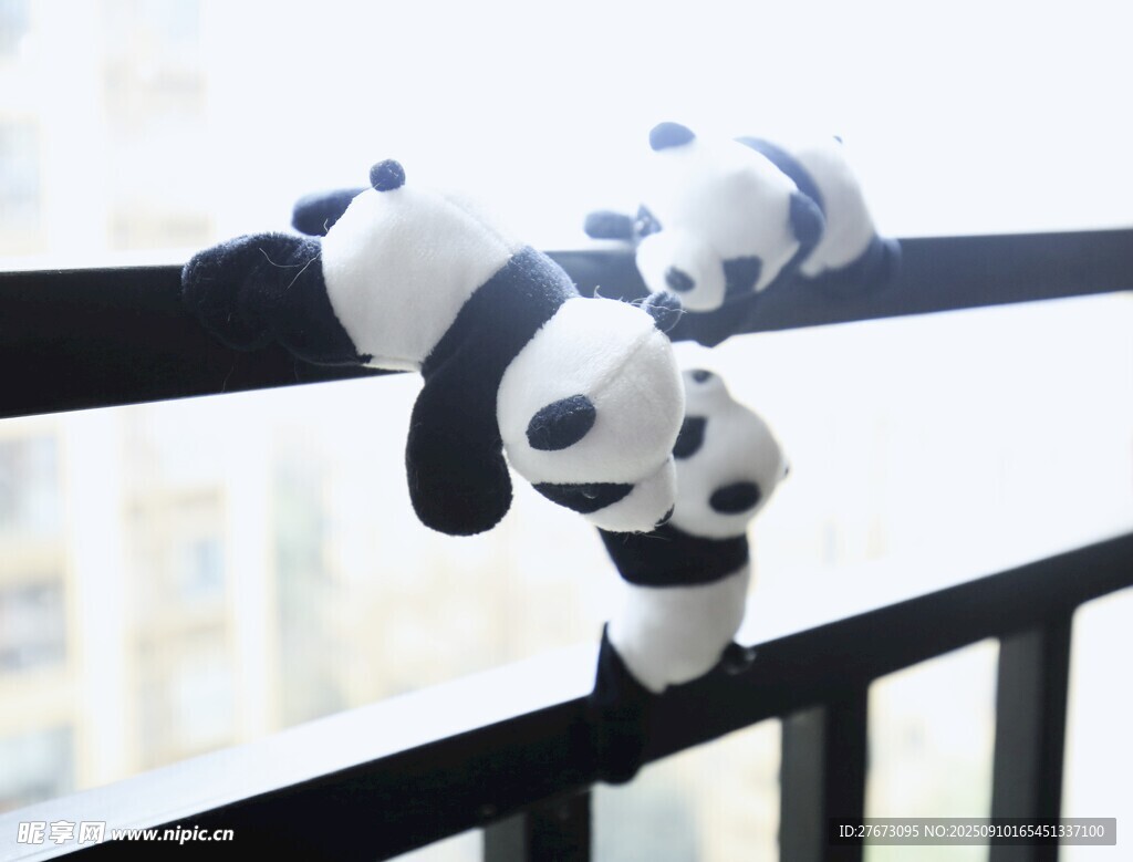 阳台栏杆上的可爱熊猫玩偶