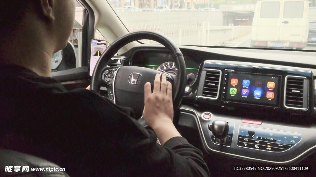驾驶员手握方向盘操作中控