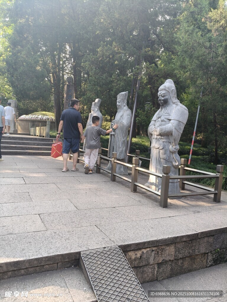 公园中游客赏古代人物雕像