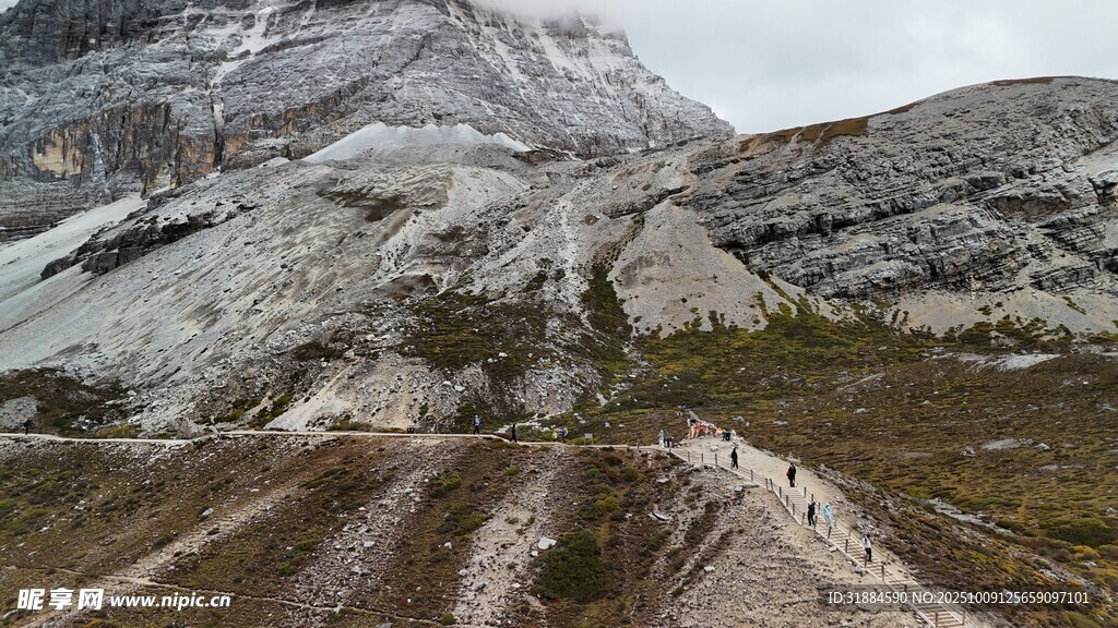 山间泥泞小路与远处雪山
