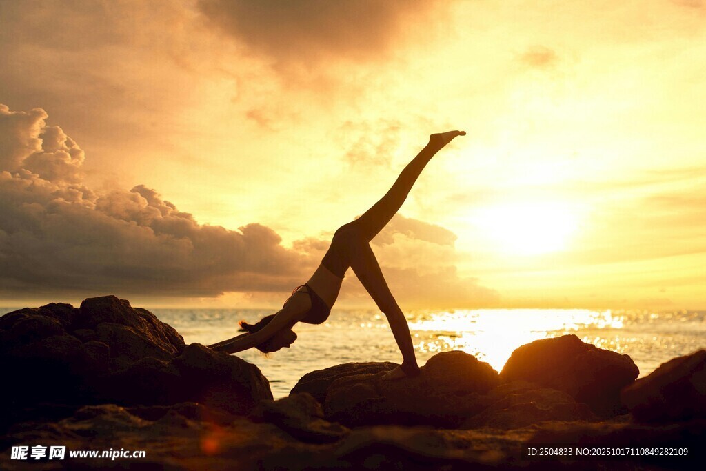 夕阳下的海边瑜伽者