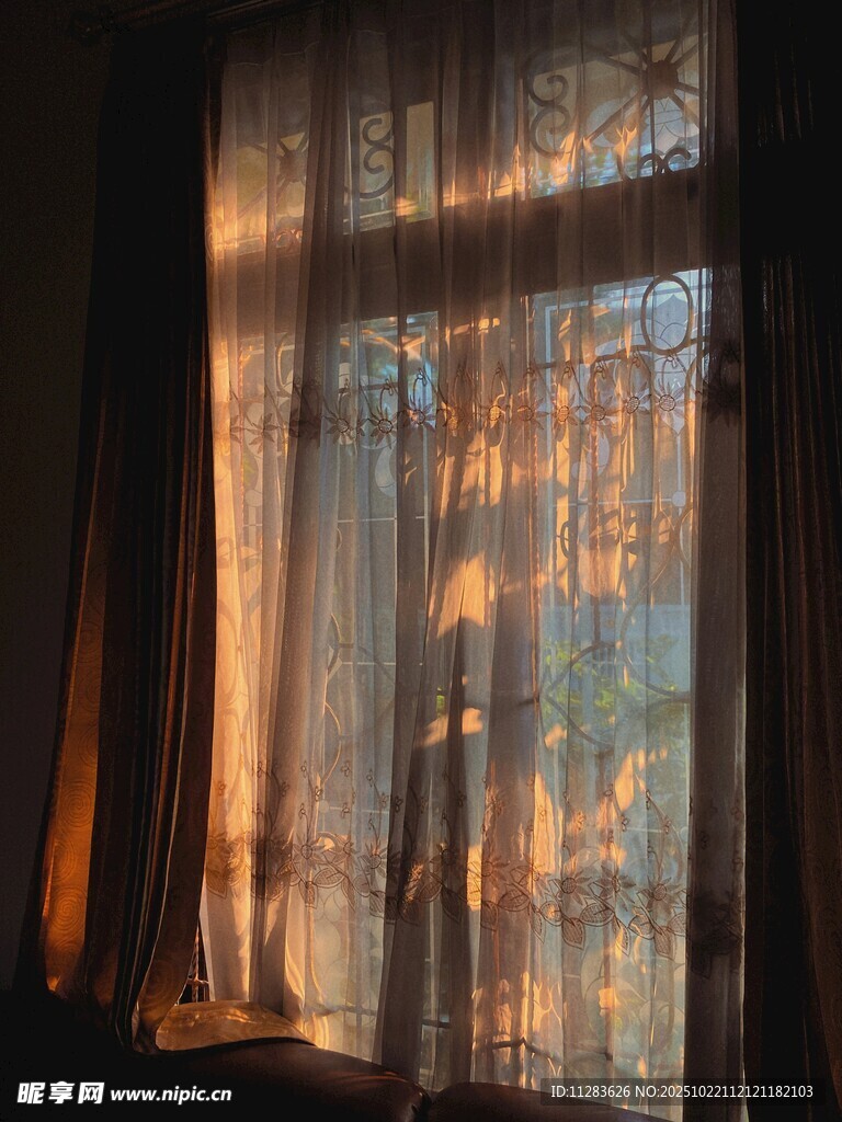透过窗帘的温暖夕阳光影