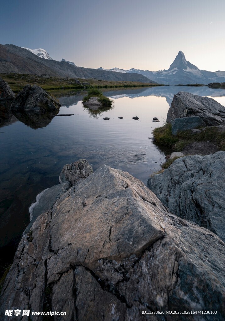 湖畔岩石与远处的壮丽山峰