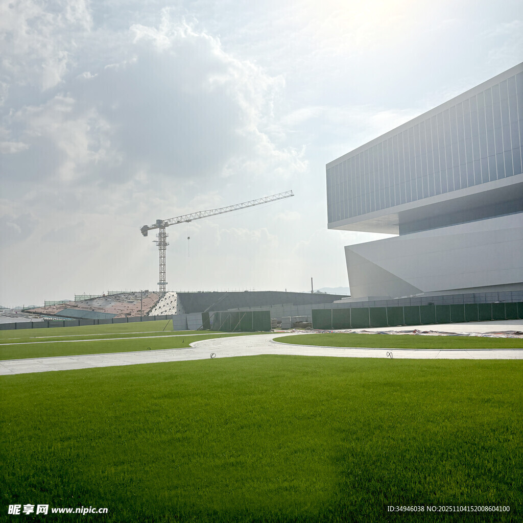 现代建筑旁的绿地与塔吊