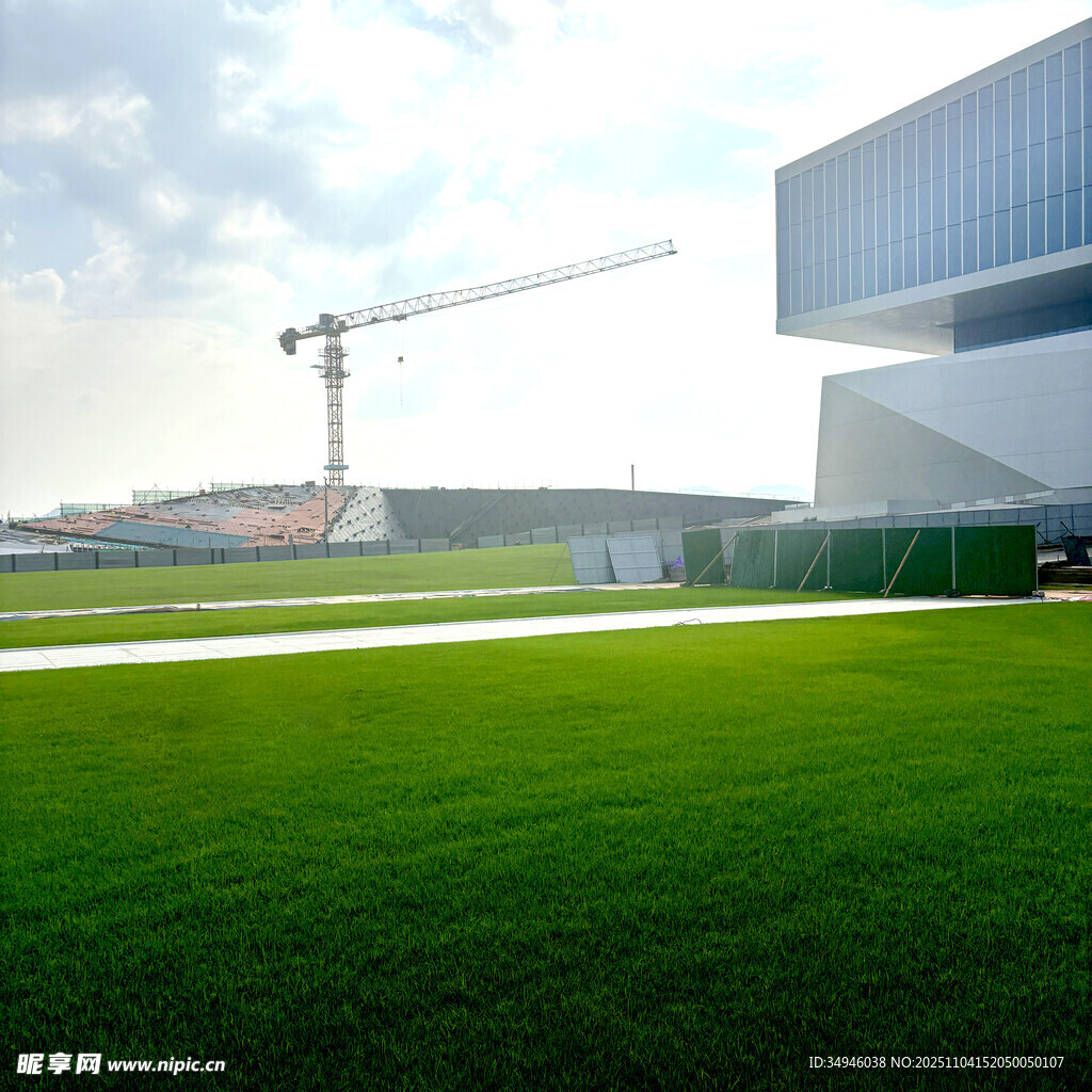 现代建筑旁的绿地与起重机