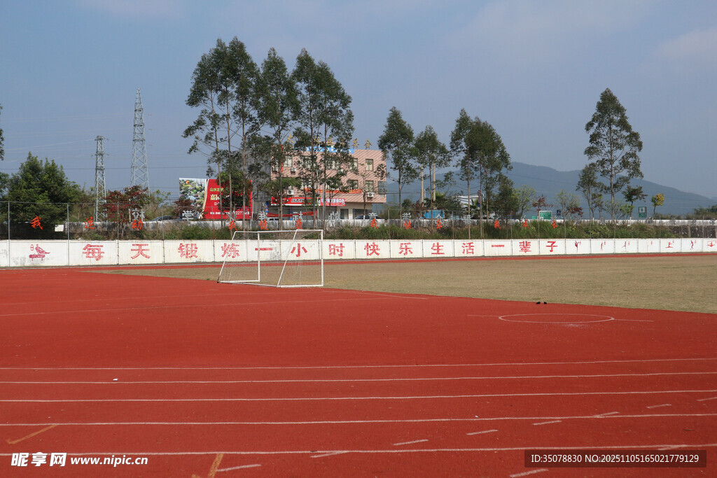 校园红色跑道与远处绿树