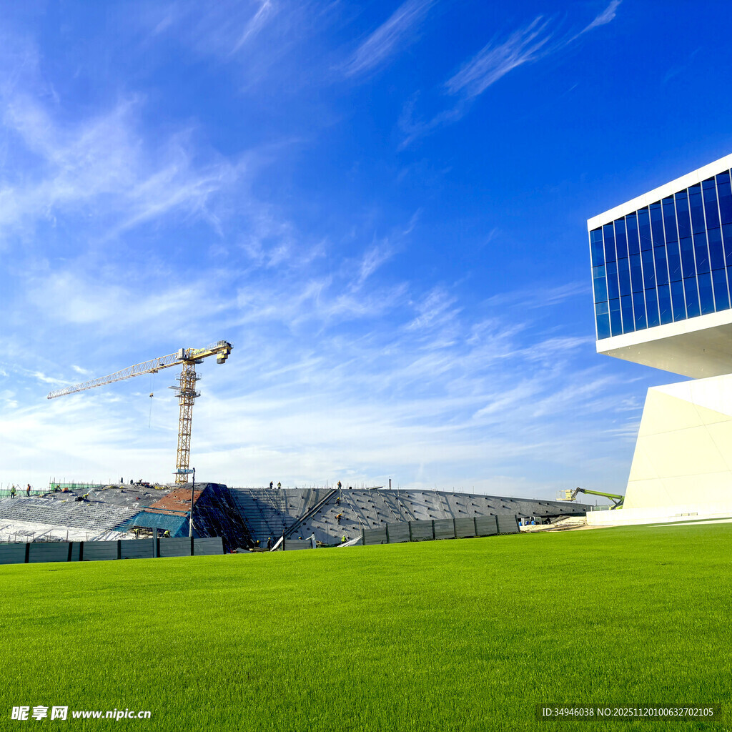 蓝天绿地旁的建筑施工场景