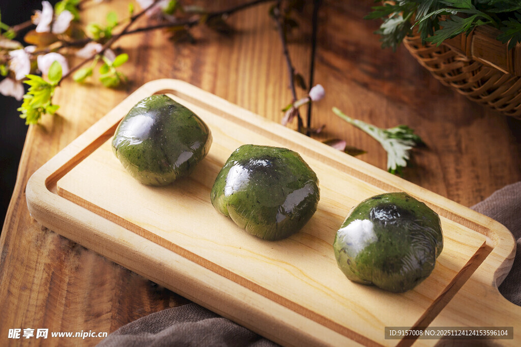 三个青团摆放在木砧板上