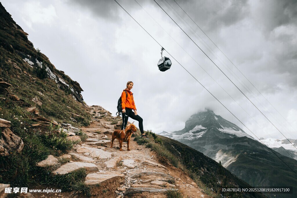 徒步者在山间缆绳下前行