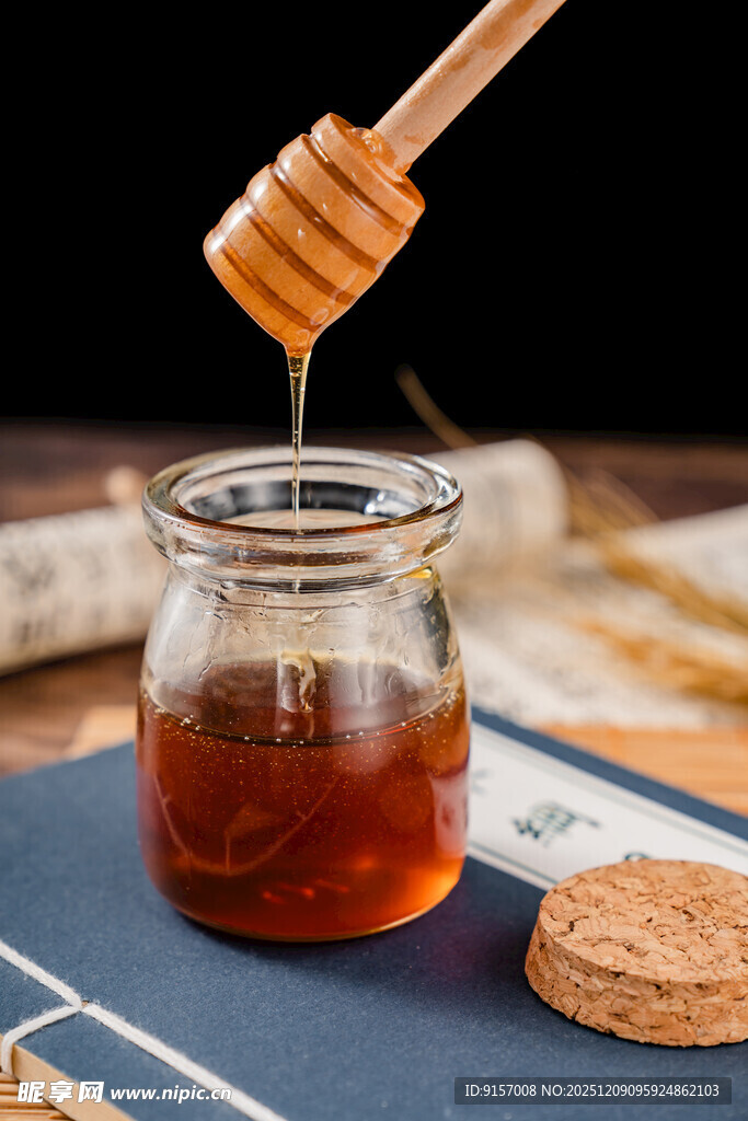 蜂蜜从木勺滴入玻璃罐中