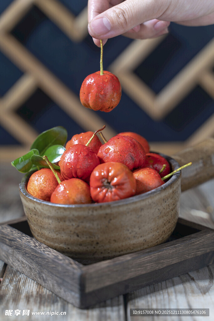 手拎番茄于木碗之上