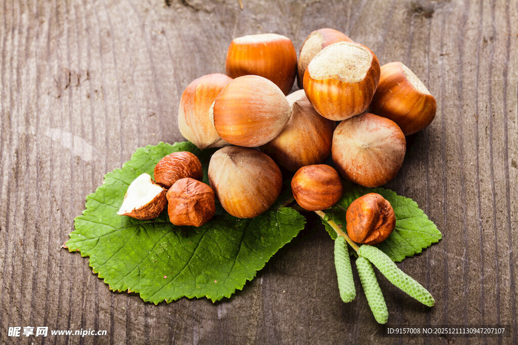 木桌上的新鲜榛子与绿叶