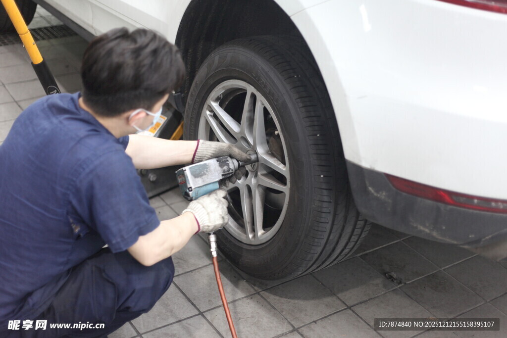 工人专注维修汽车轮胎