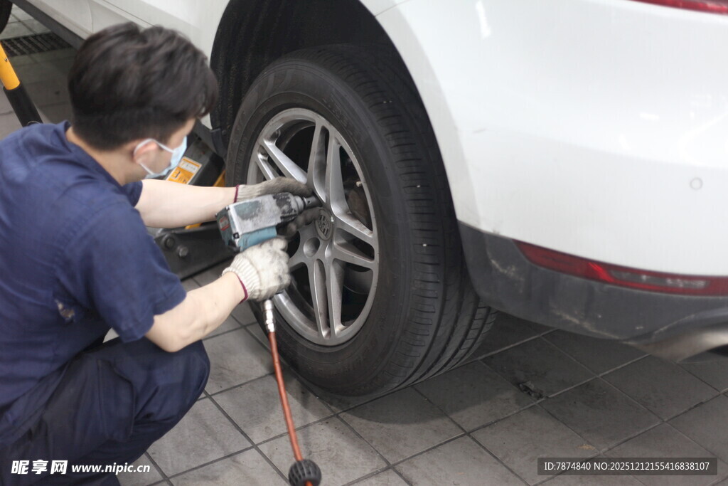 工人专注维修汽车轮胎