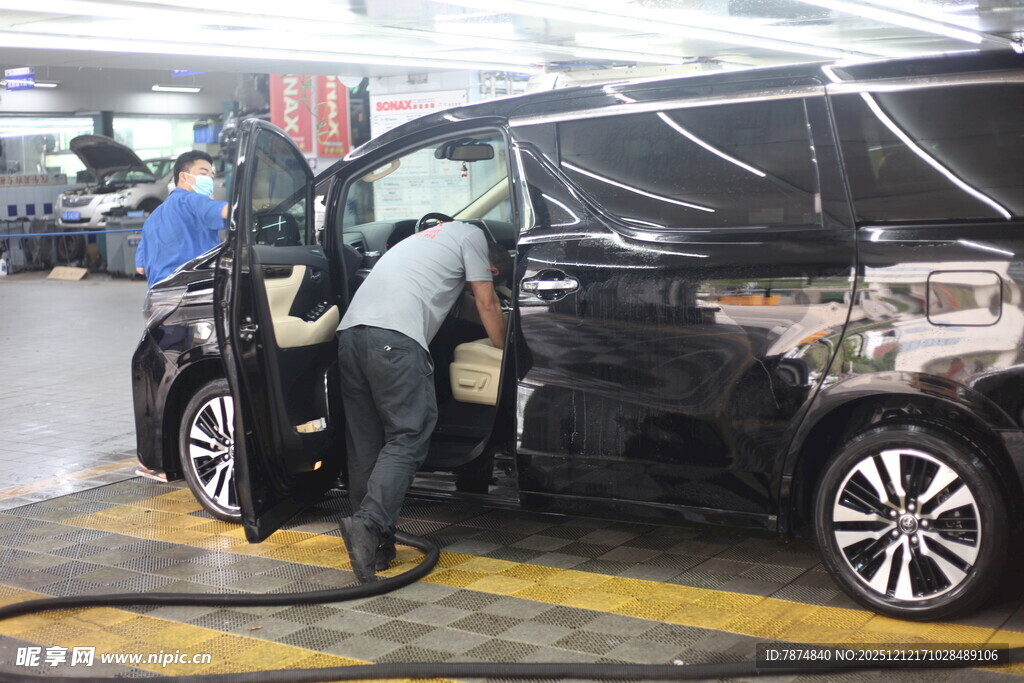 工人检修黑色轿车