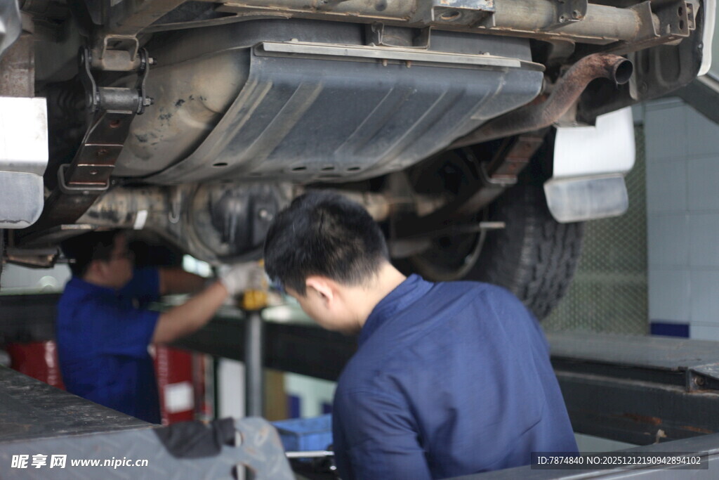 汽修工人专注检修汽车底盘