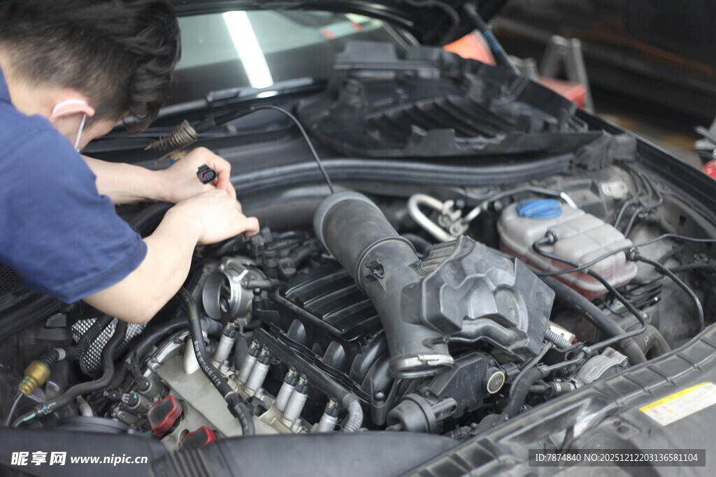 工人专注检修汽车发动机