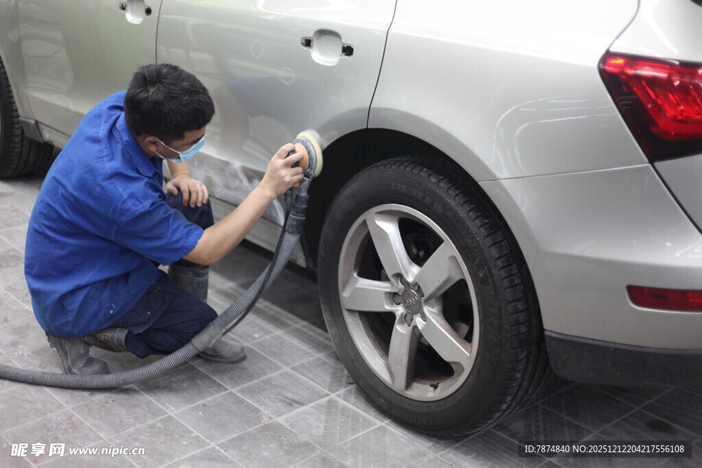 工人专注给汽车轮毂喷漆