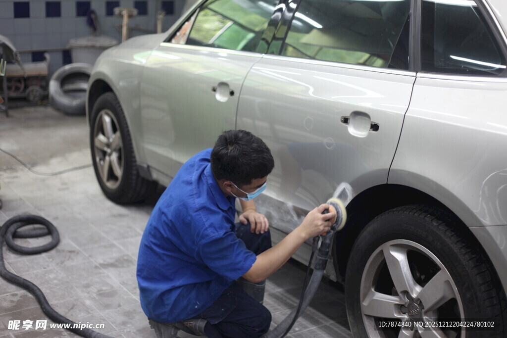 工人专注进行汽车喷漆作业