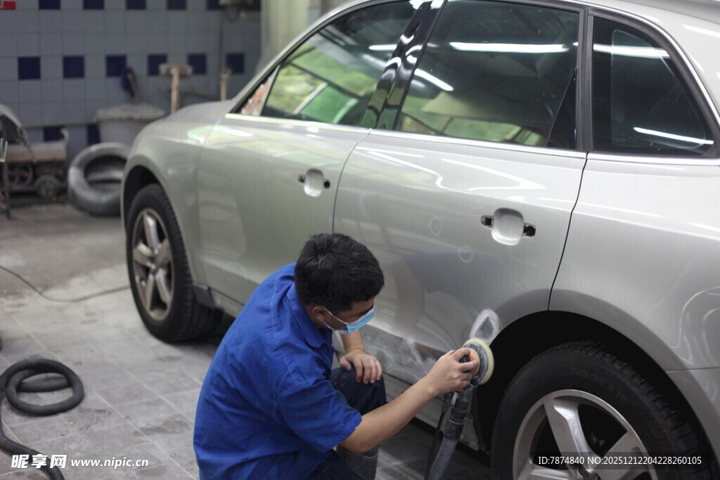 工人专注维修银色汽车