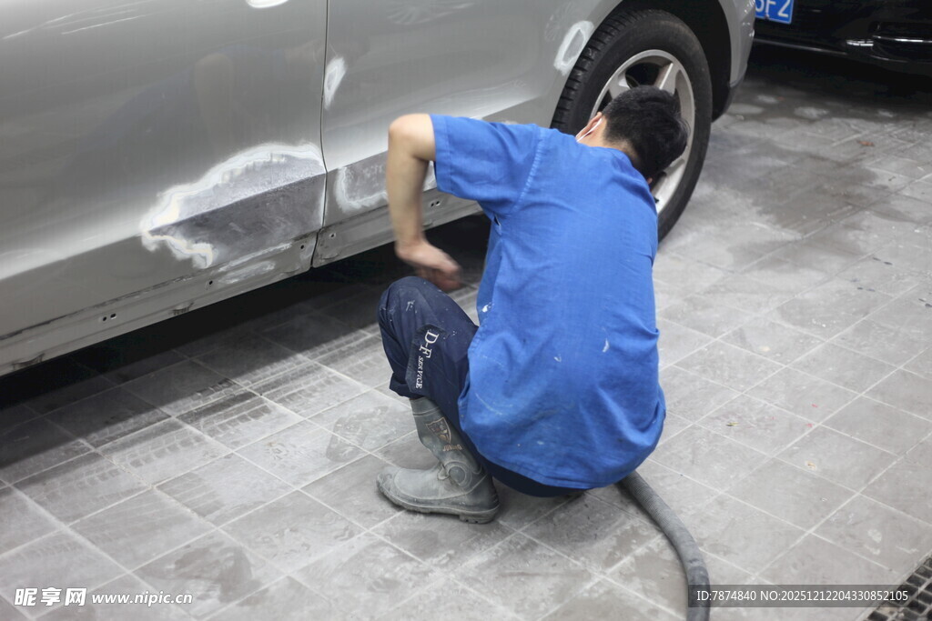 工人专注修补汽车车身