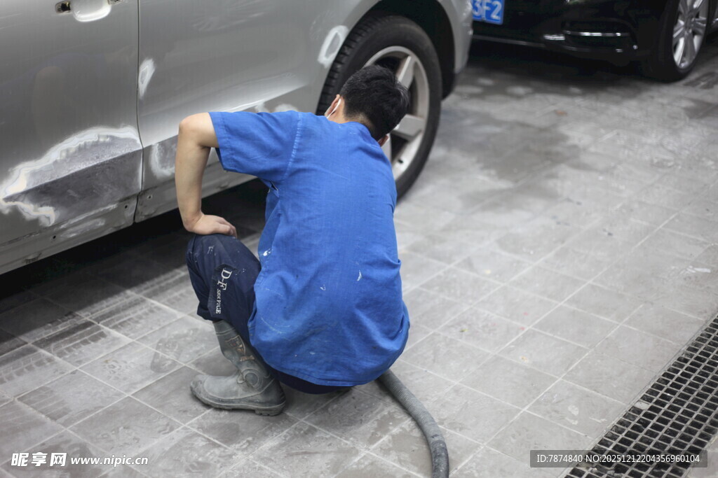 工人专注维修汽车轮胎