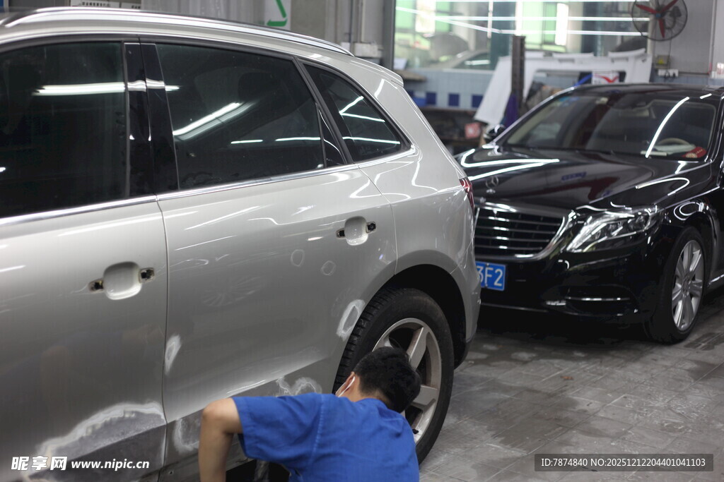 工人维修车间内的汽车