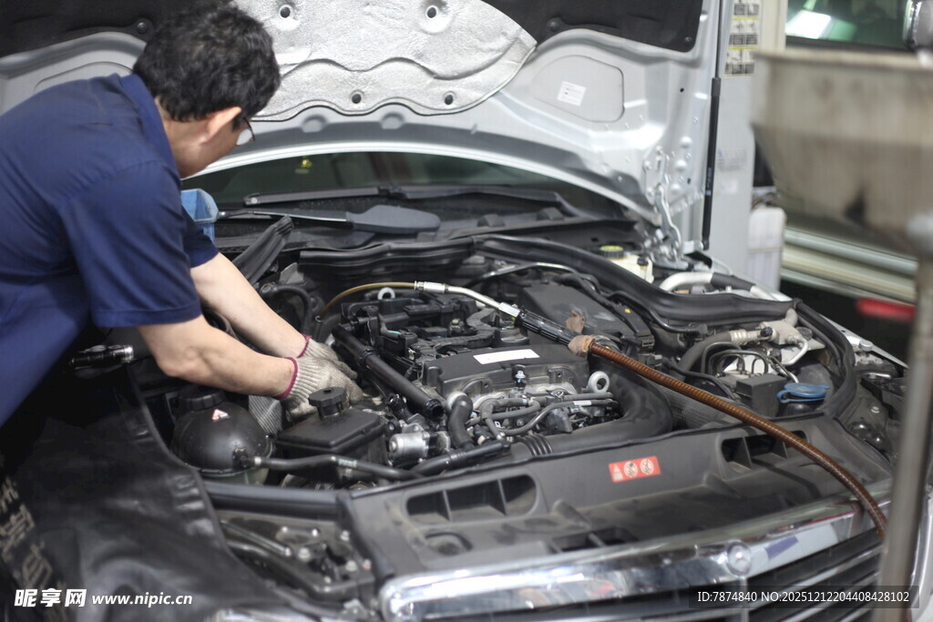 汽修工人专注检修汽车引擎