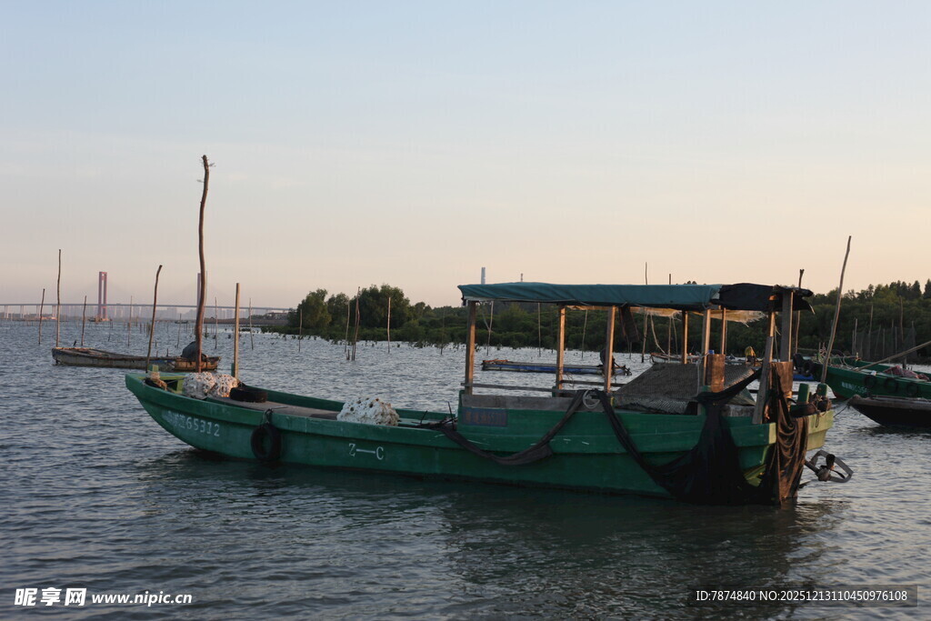 夕阳下停泊的绿色渔船