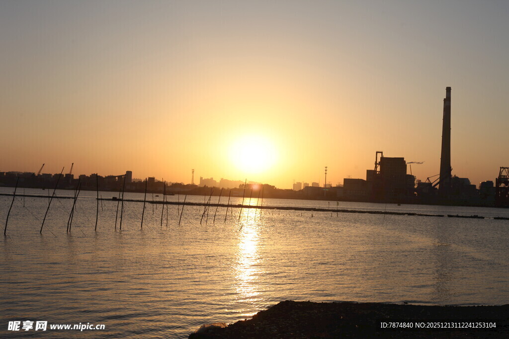 夕阳下的水域与远处烟囱