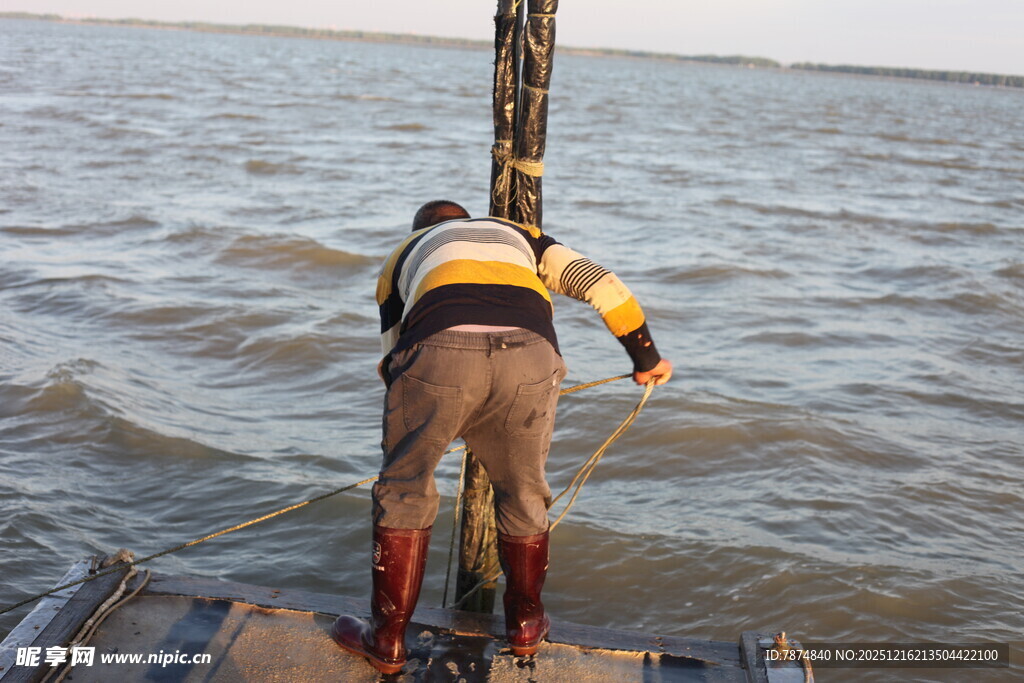男子于船边俯身探向水面