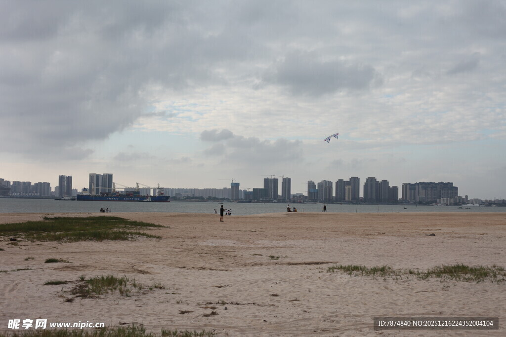 阴天的城市边空旷沙滩景色