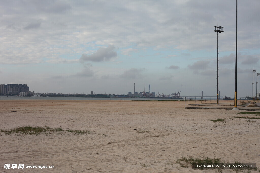 空旷沙滩与远处港口景象